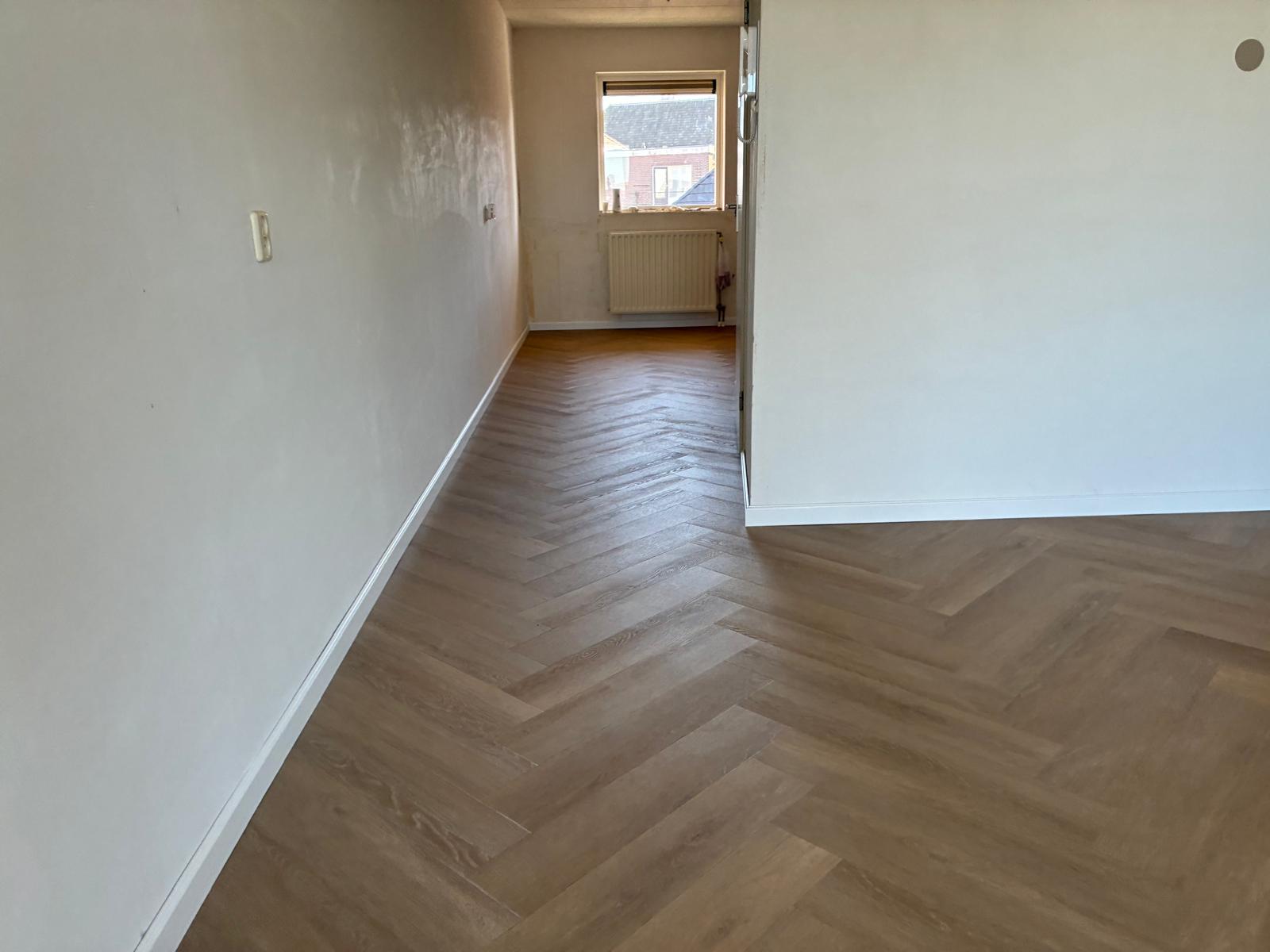 Lange kamer met de visgraat strak langs de plinten afgewerkt