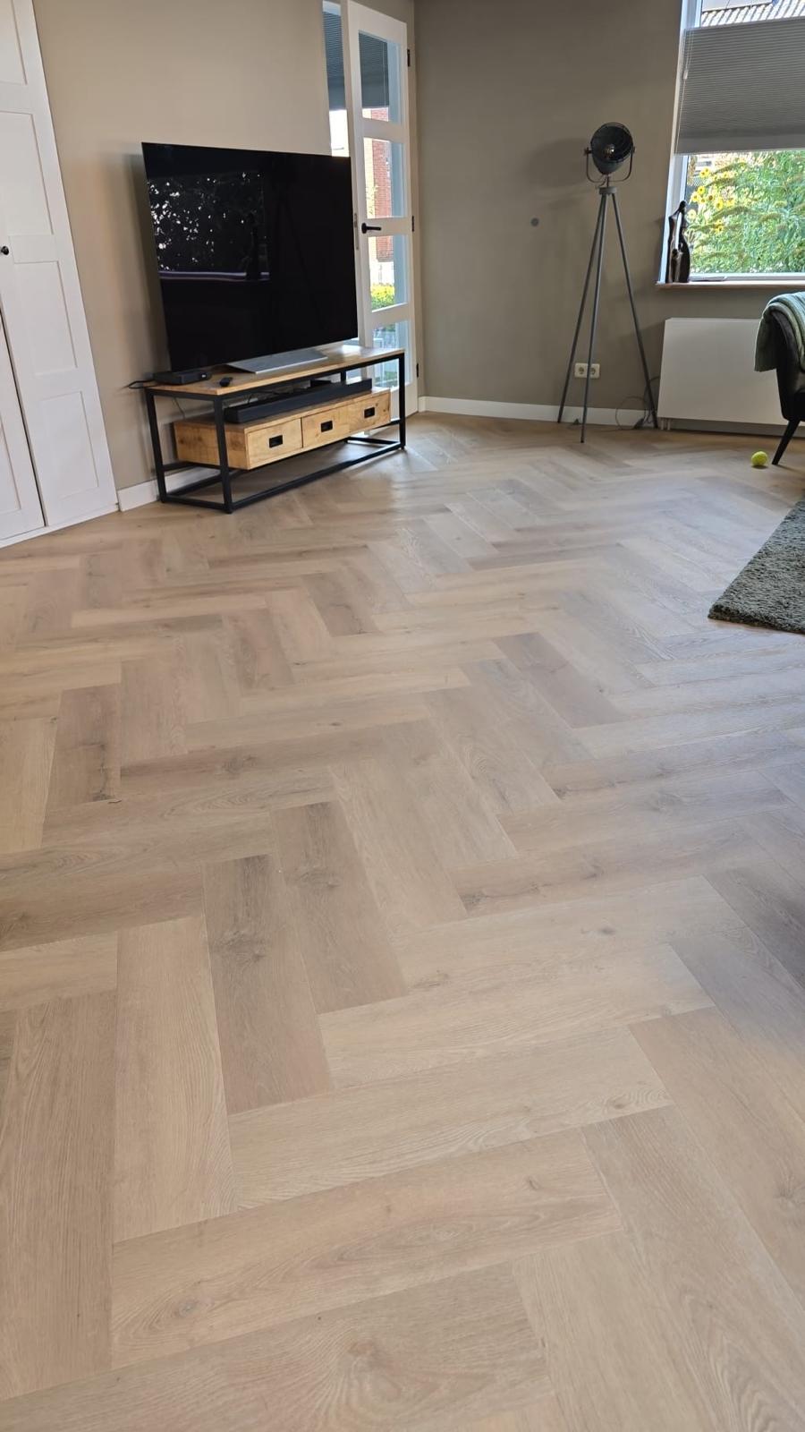 Lichte eiken visgraatvloer in een ingerichte woonkamer in Nijverdal
