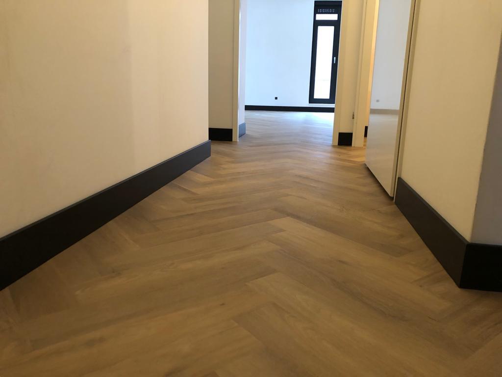 Stijlvolle visgraatvloer met donkere plinten in Enschede